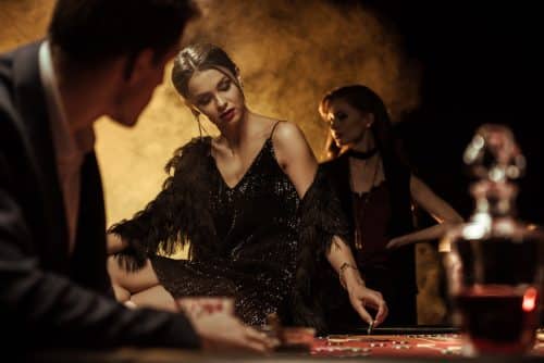 Man-looking-at-beautiful-woman-sitting-on-poker-ta-2023-11-27-05-04-48-utc