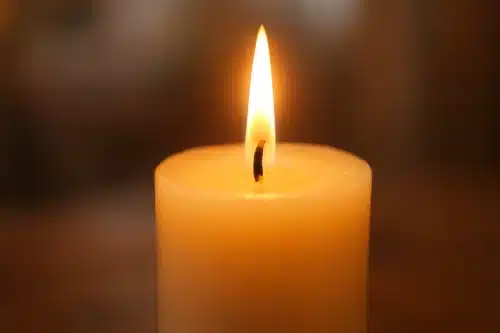 Gros plan d'une bougie allumée avec une flamme douce et chaleureuse dans une atmosphère calme et apaisante