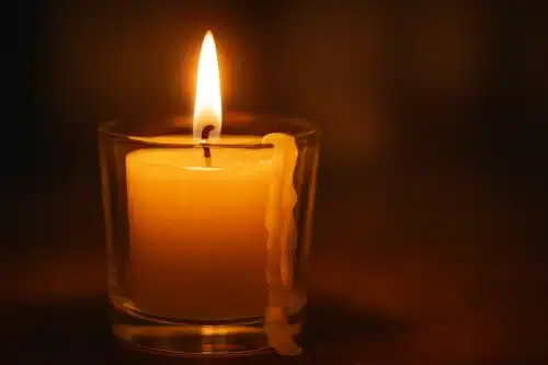 Bougie allumée dont la cire coule vers la droite, ambiance chaleureuse et spirituelle